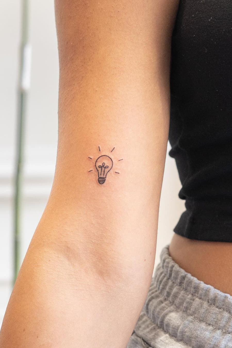 Tiny light bulb tattoo