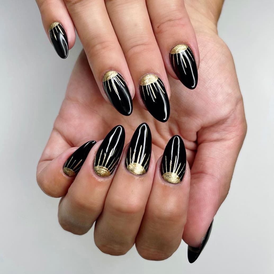 Short black almond nails with golden sun