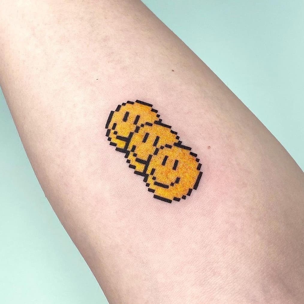 Pixel smiley tattoo