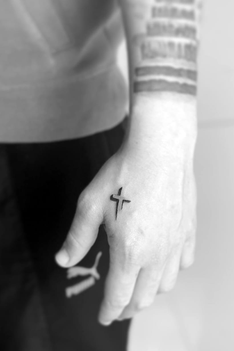 Small cross tattoo on hand