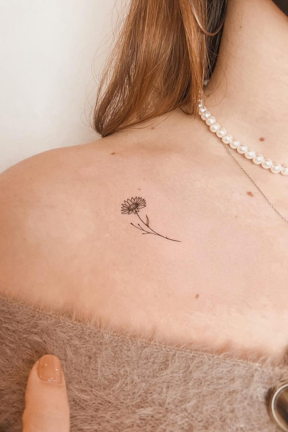 Small sunflower tattoo on collarbone