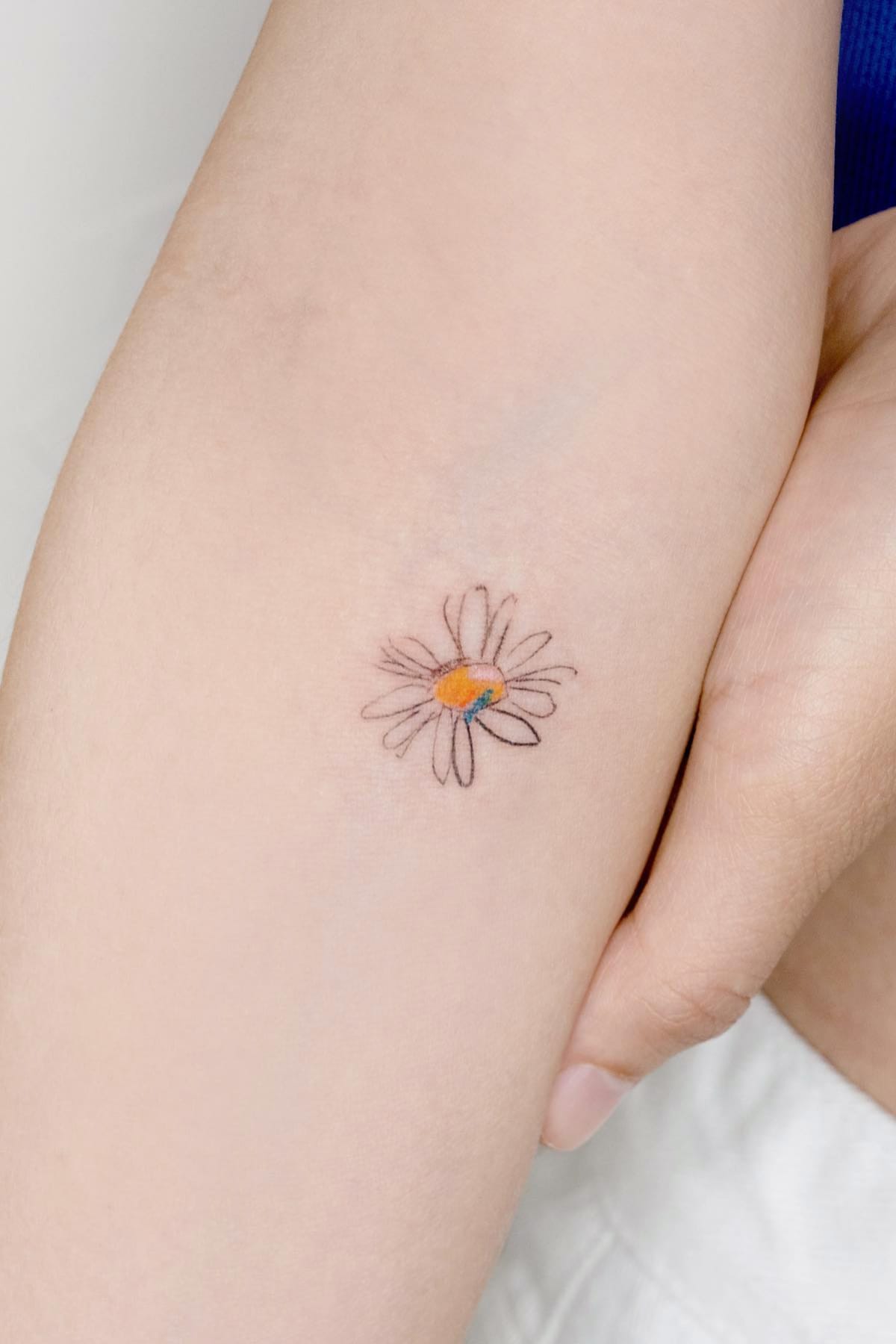 minimalist daisy tattoo