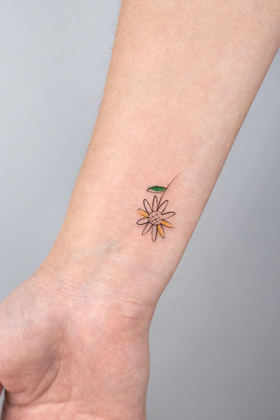 small sunflower tattoo on wrist