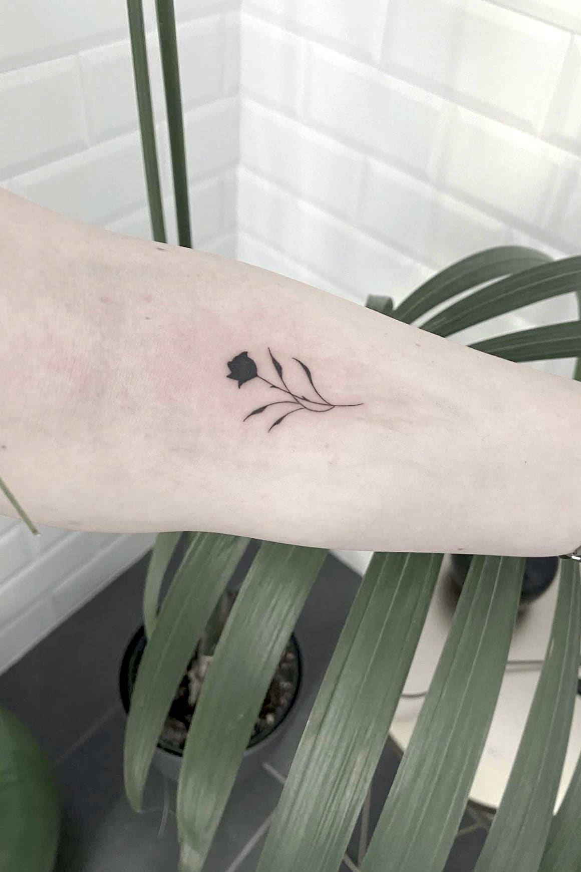 Cute small black rose tattoo