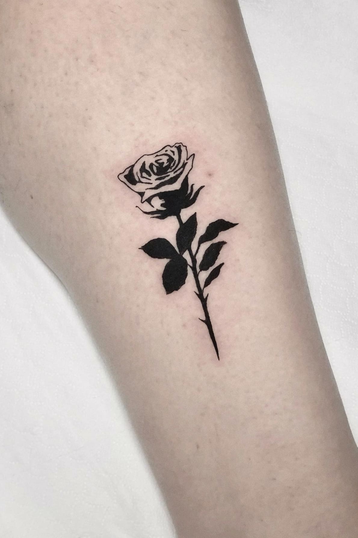 Small black and white rose tattoo