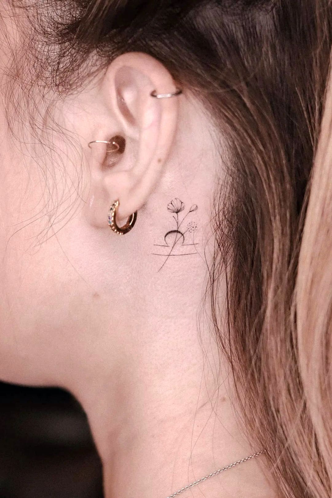 Libra tattoo behind the ear