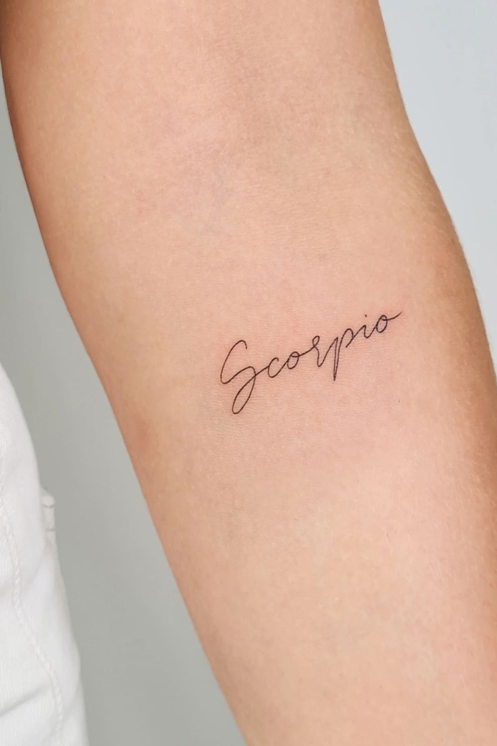 Scorpio word tattoo