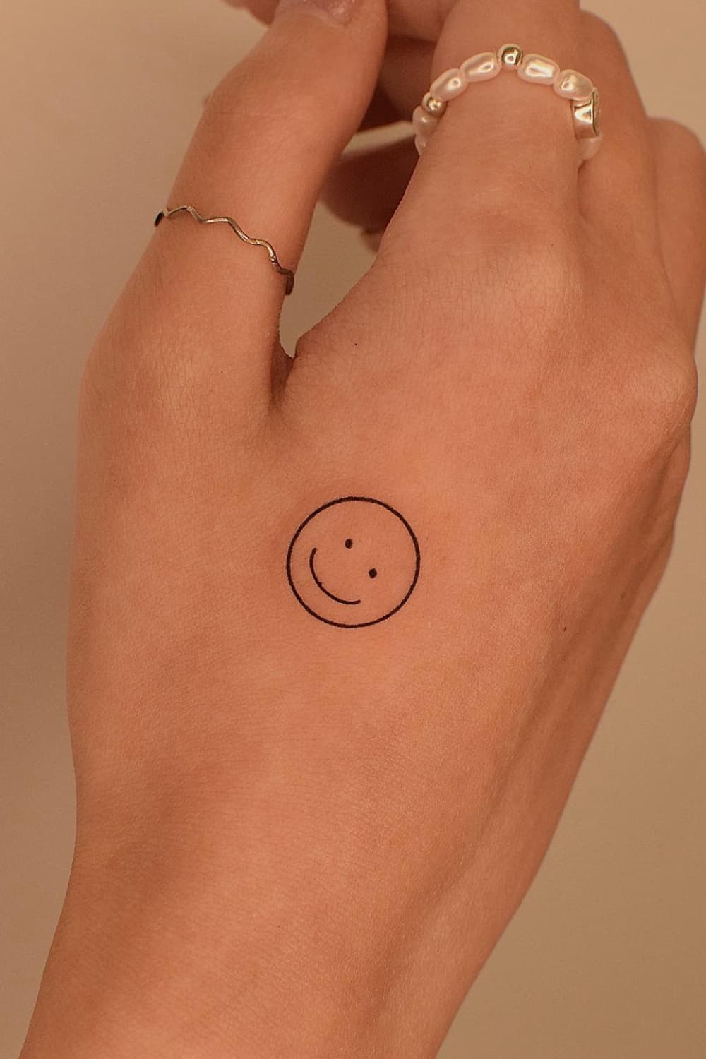 Small Smiley Hand Tattoo