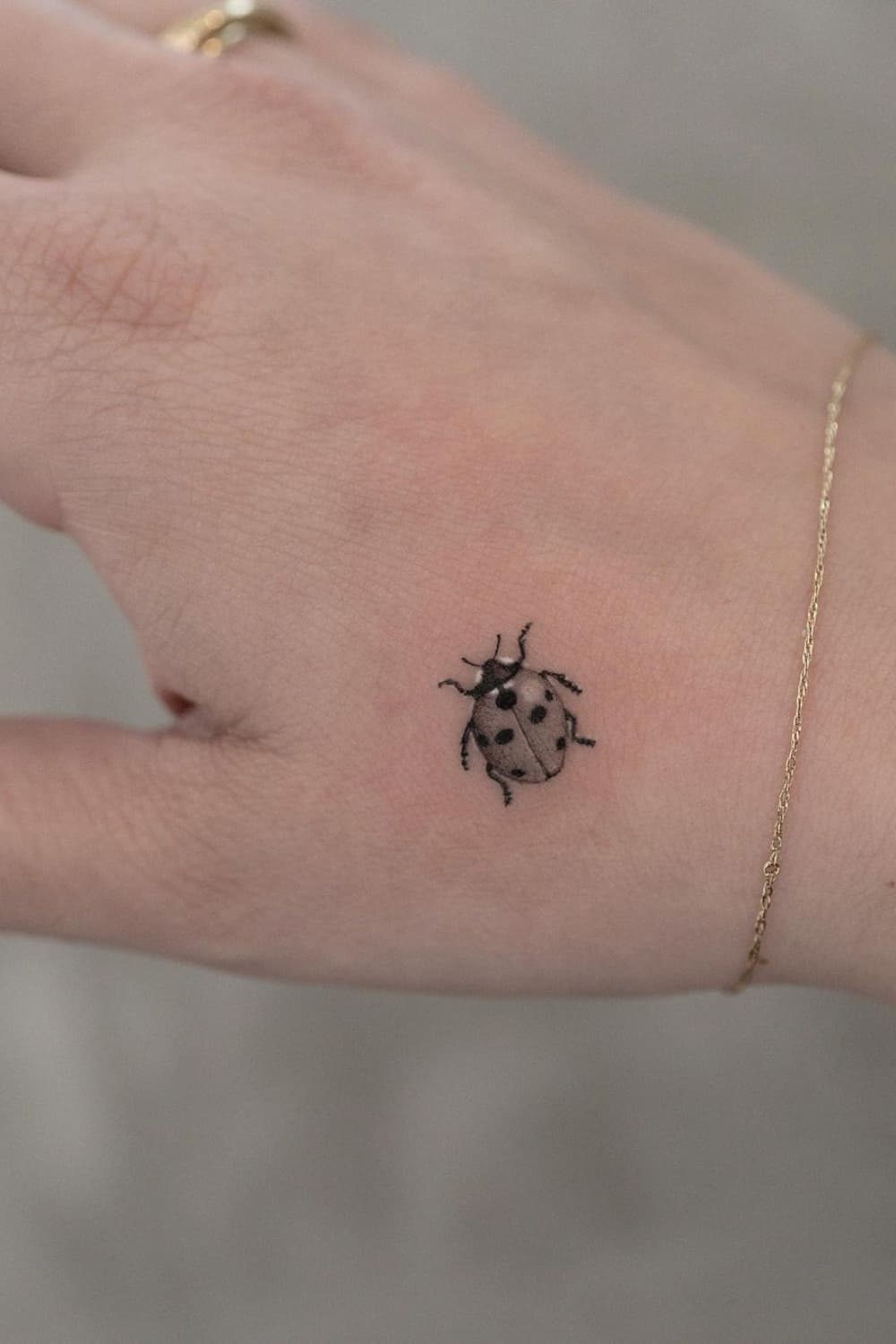 Small Ladybug Hand Tattoo