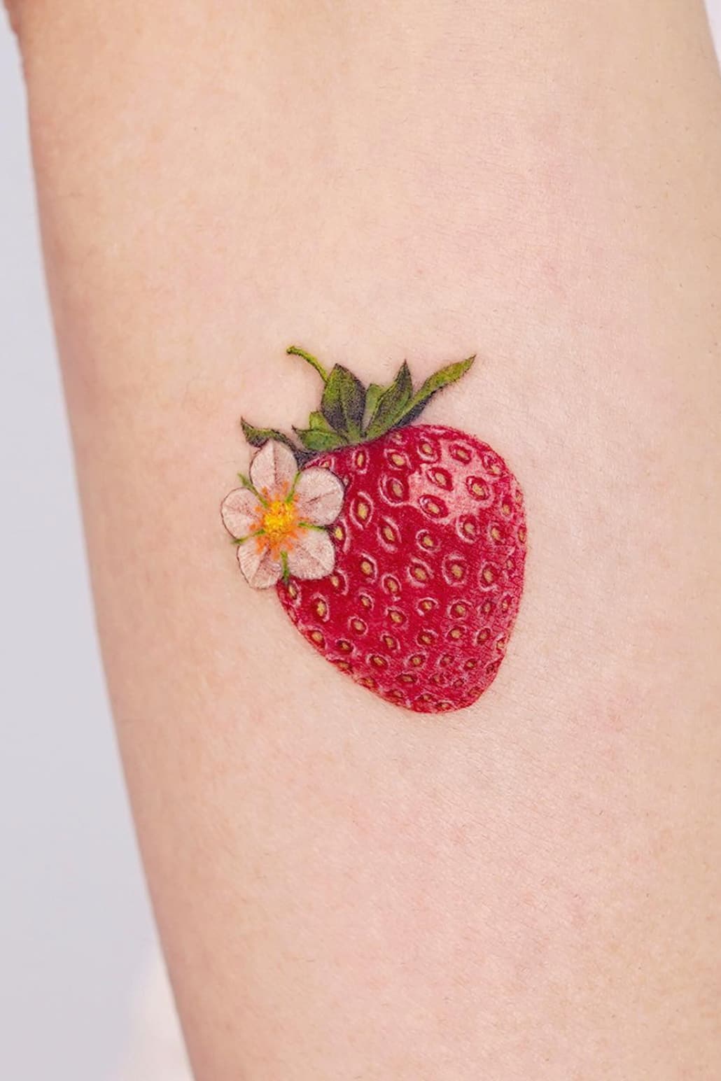 Tatouage de fraise avec fleur de fraise