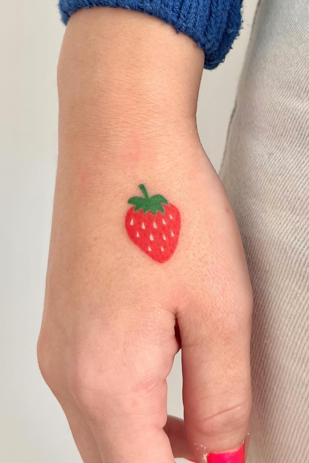 Tatouage à la fraise sur la main